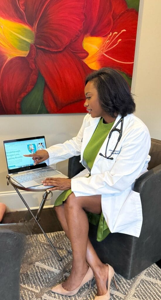 Picture of Dr. Deniece at table, teal suit